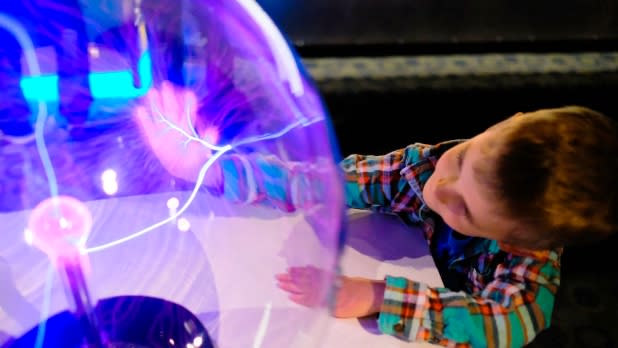 Young boy touches an orb at the Buffalo Science Museum