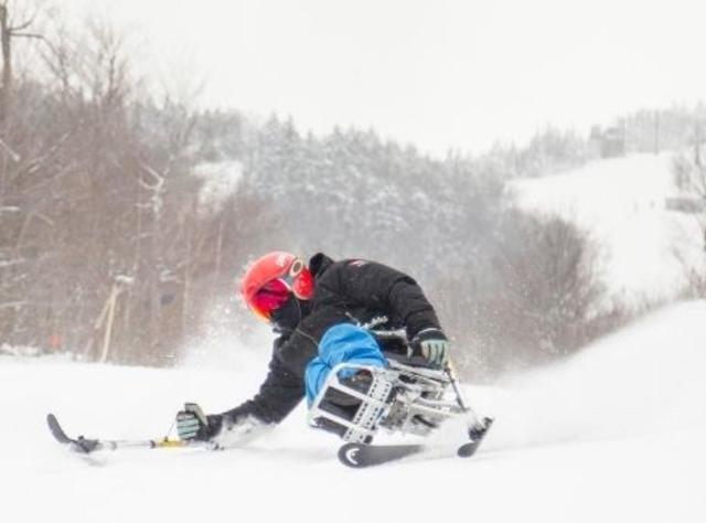 An adaptive skier in action on a snow-covered slope on Whiteface Mountain