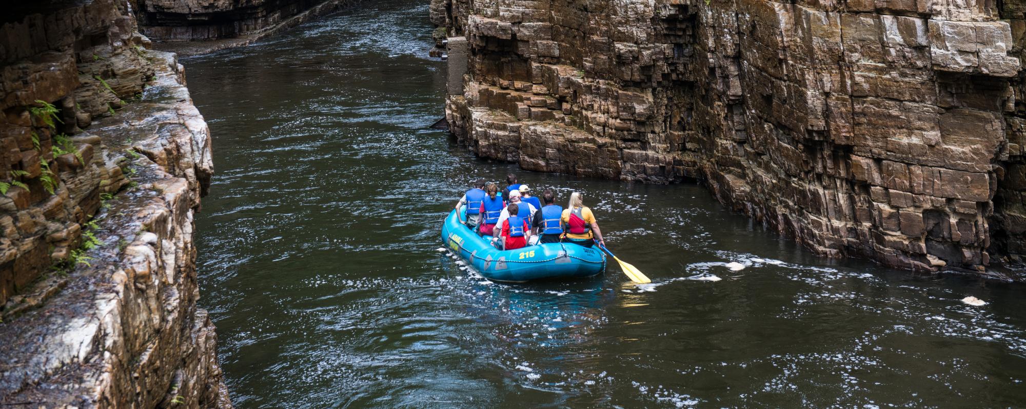 People in a blue raft in Ausable Chasm