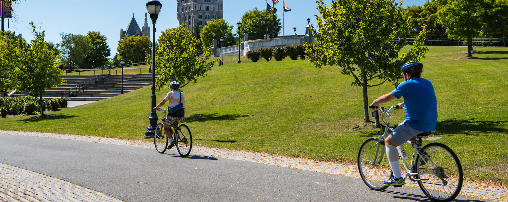 A photo of two people bicycling on the Empire Trail Corning Preserve