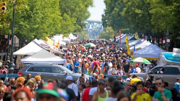 A crowd of people wandering the streets at Harlem Week