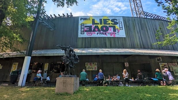 Delacorte Theater in Central Park, NYC, advertising the summer plays for Shakespeare in the Park.