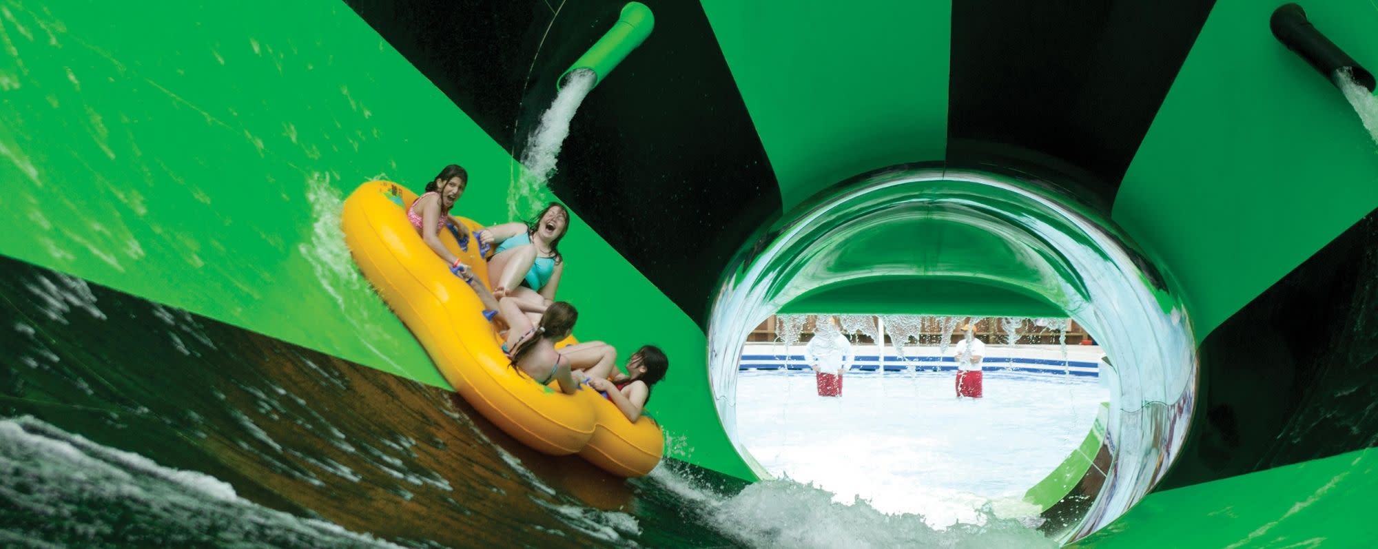 Four people ride the Alien Invasion water slide at Splish Splash Water Park