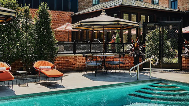 A pool, lounge chairs, and part of a building