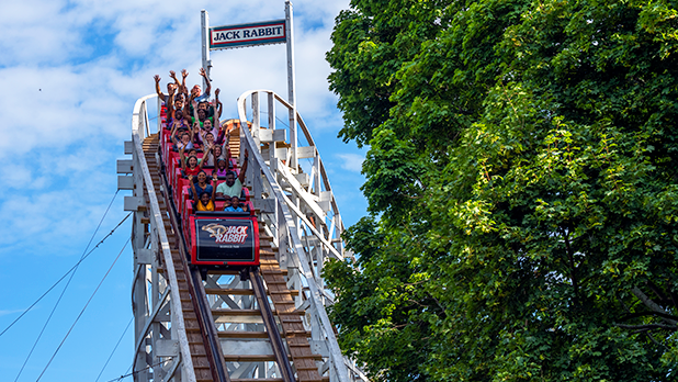 People raise their arms in glee at the first drop on the Jack Rabbit roller coaster at Seabreeze Amusement Park