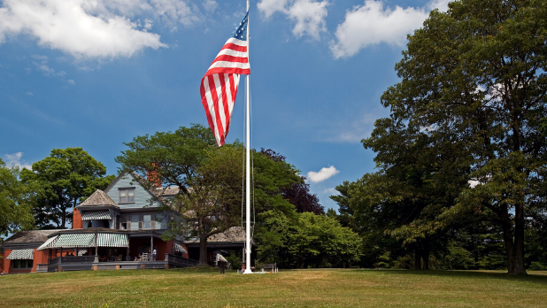 The lawn in front of the Sagamore Hill National Historic Site showing the exterior of the building an American flag