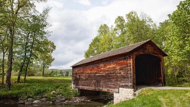 The wood brown Hyde Hall covered bridge in the forest